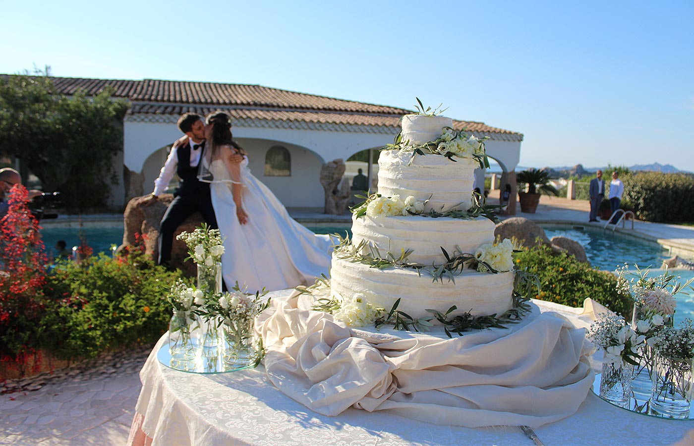 novizi sposi si baciano vicino alla torta matrimoniale a quattro piani all'Hotel Pulicinu, location per Matrimoni in Sardegna